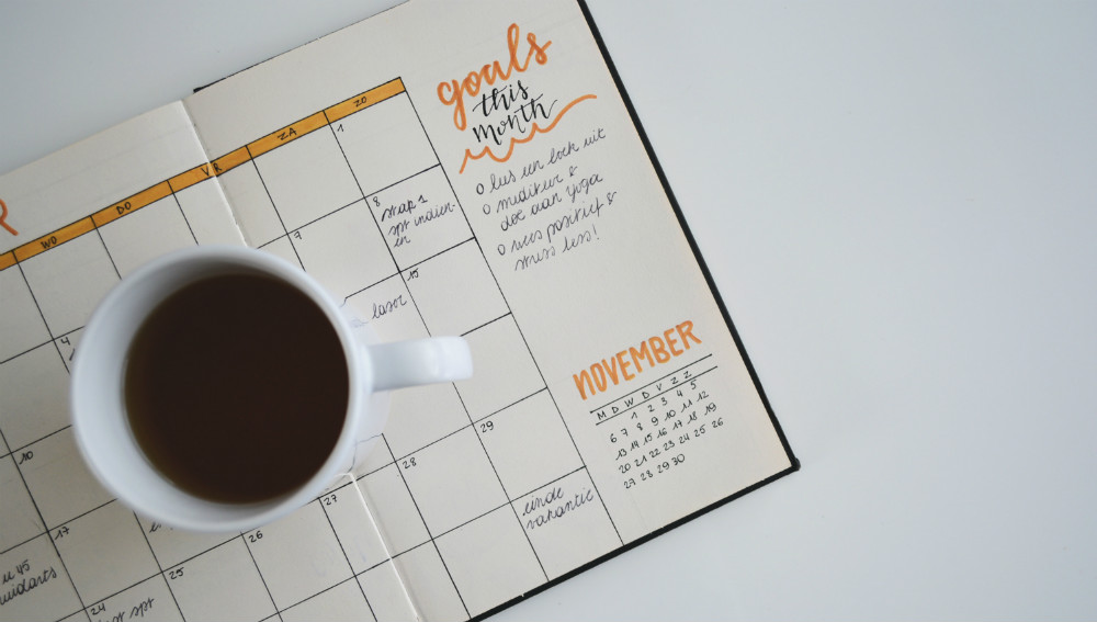 goals planner and a cup of coffee